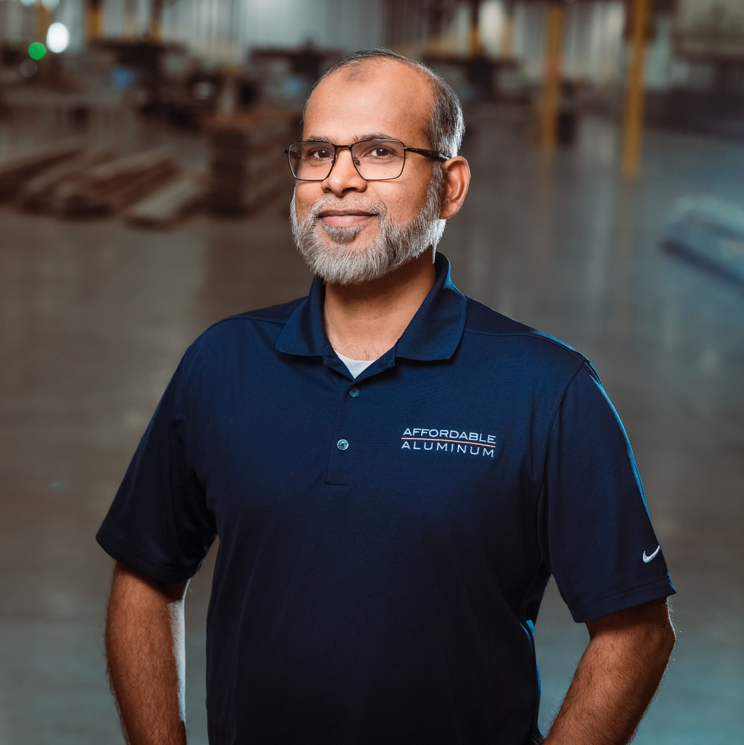 Afaq Standing in Warehouse Wearing Affordable Aluminum Shirt